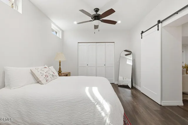 a spacious bedroom with a bed and a ceiling fan