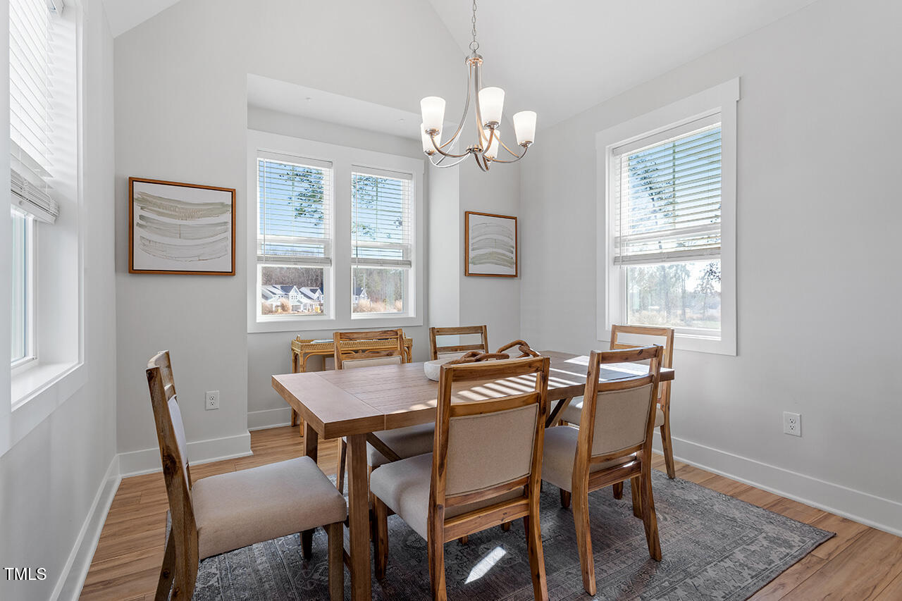 539 Vine Parkway Pittsboro, NC 27312 - Photo 12 of 35 a view of a dining room with furniture a chandelier and wooden floor