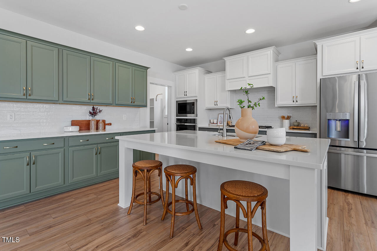 539 Vine Parkway Pittsboro, NC 27312 - Photo 14 of 35 a kitchen with a sink a microwave a refrigerator and cabinets