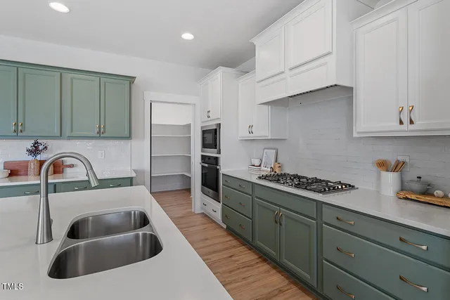 a kitchen with sink a stove and cabinets