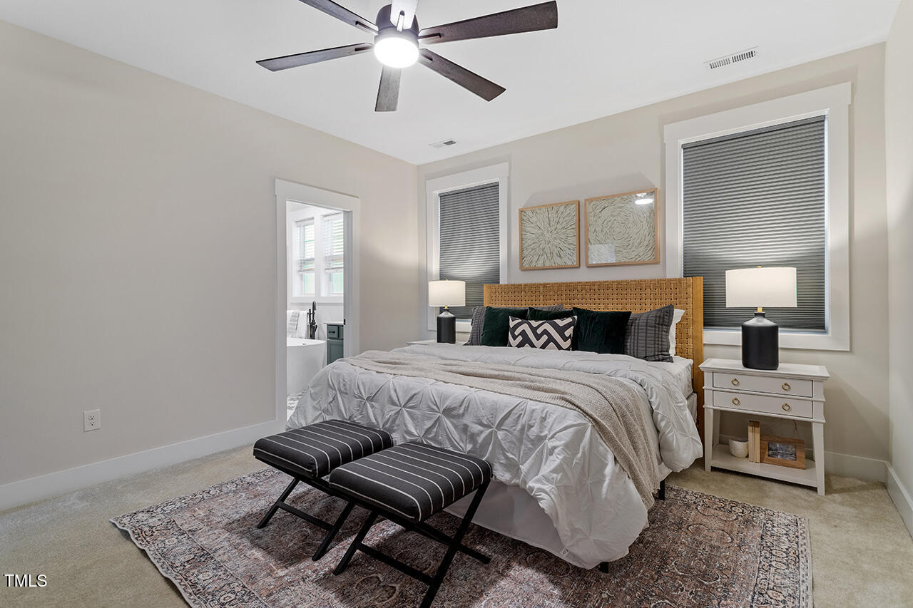 539 Vine Parkway Pittsboro, NC 27312 - Photo 21 of 35 a bedroom with a bed and a chandelier