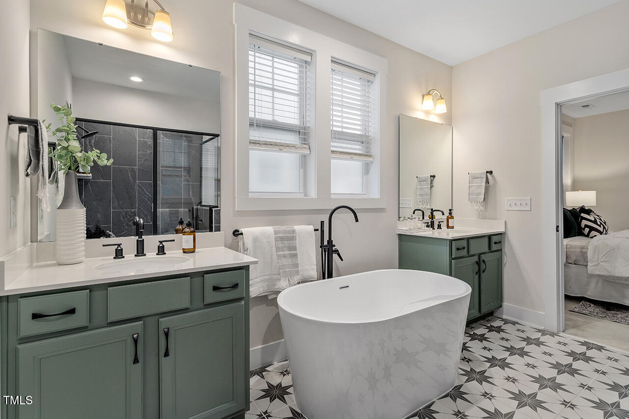 539 Vine Parkway Pittsboro, NC 27312 - Photo 23 of 35 a bathroom with a double vanity sink a mirror and a bathtub