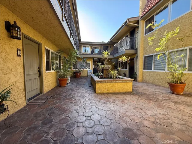 a view of a house with many windows next to a brick wall