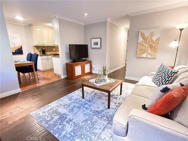 a living room with furniture a flat screen tv and kitchen view