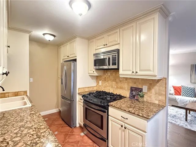 a kitchen with stainless steel appliances granite countertop a stove a refrigerator and a sink
