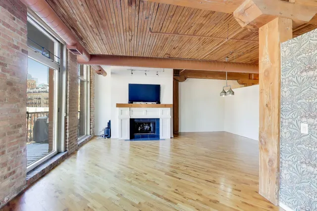 a view of an empty room with a fireplace and a window