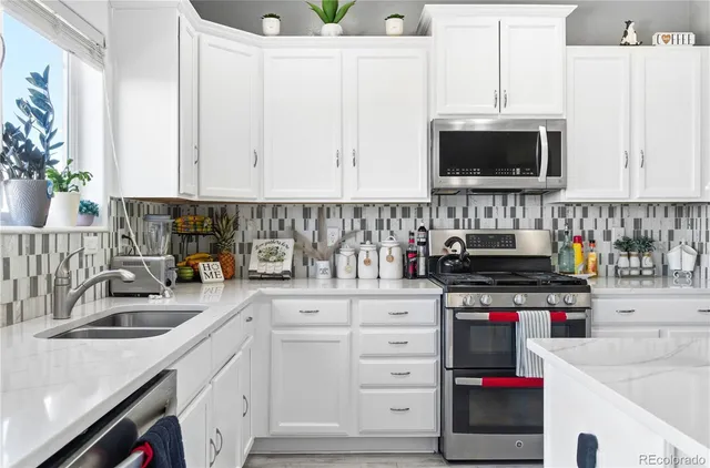 a kitchen with stainless steel appliances granite countertop a sink a stove and a microwave