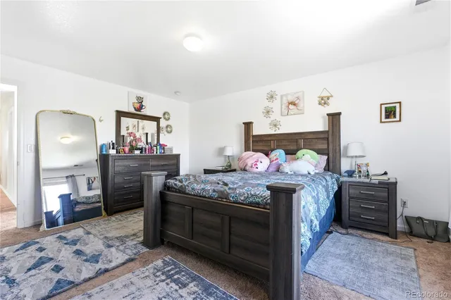 a bedroom with a bed a flat screen tv and dresser