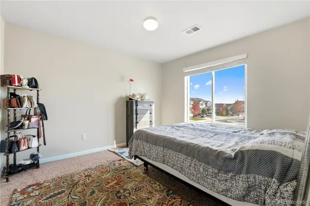 a bedroom with a large bed and wooden floor