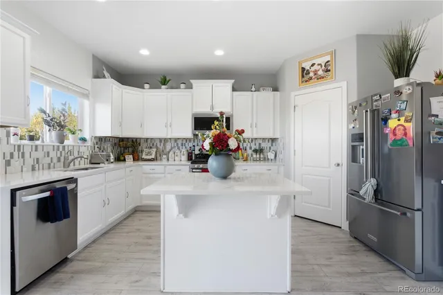 a kitchen with stainless steel appliances a refrigerator sink and cabinets