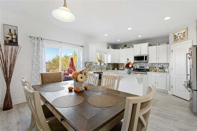 a kitchen with a dining table chairs sink and cabinets