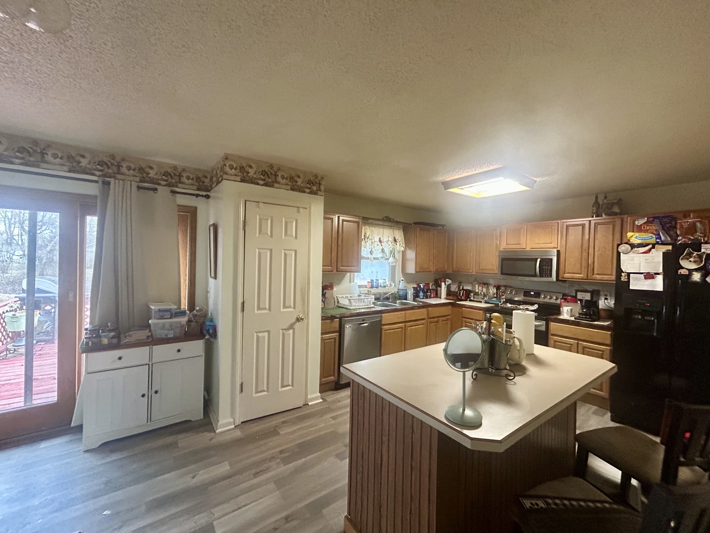 6 Carriage Lane Metropolis, IL 62960 - Photo 23 of 35 a kitchen with a sink dishwasher a kitchen island with chairs and wooden floor