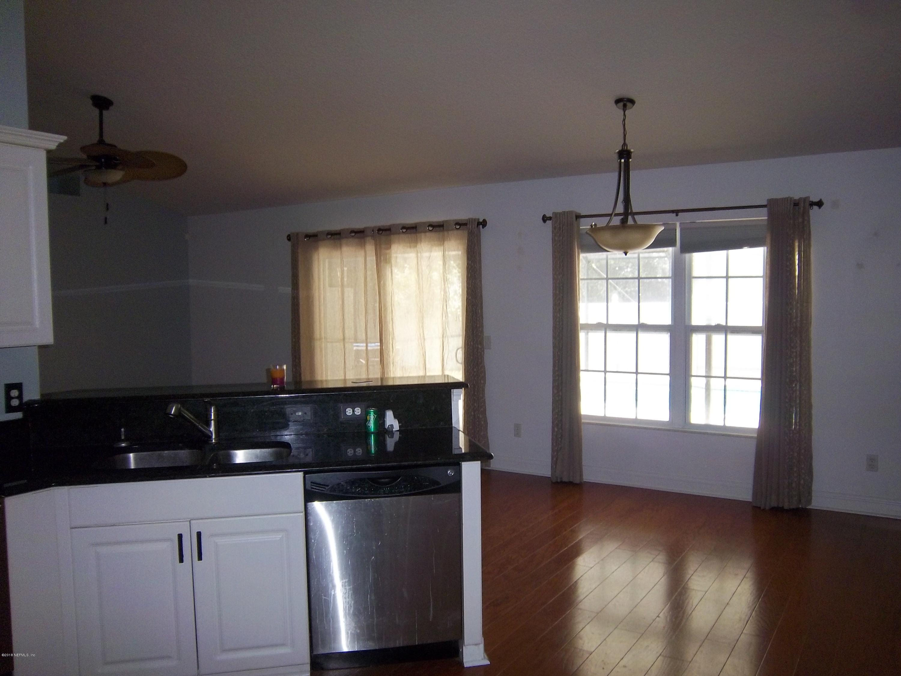 518 Jasmine Road St. Augustine, FL 32086 - Photo 8 of 27 a kitchen with granite countertop white cabinets and black appliances