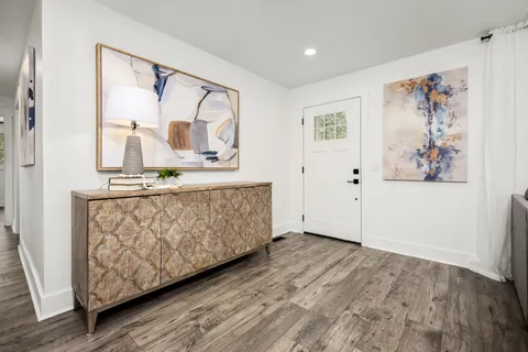 a kitchen with stainless steel appliances a dining table chairs and wooden floor