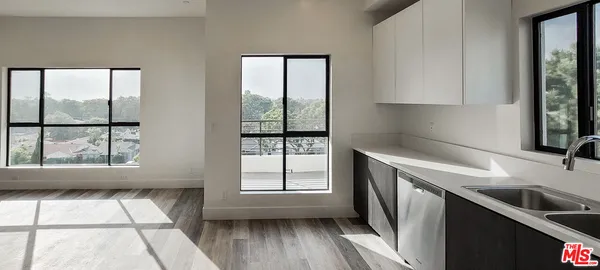 a kitchen with a refrigerator sink and wooden floor