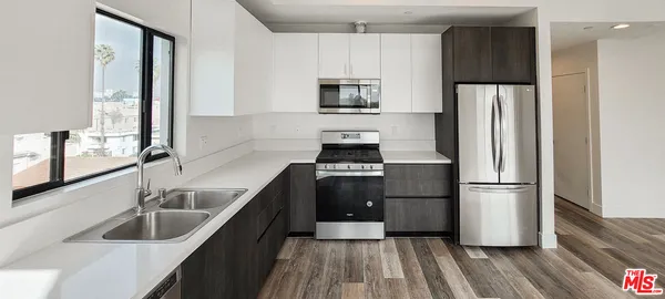 a kitchen with a table chairs refrigerator and cabinets