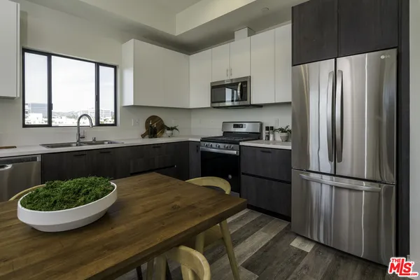 a large kitchen with stainless steel appliances granite countertop a large window