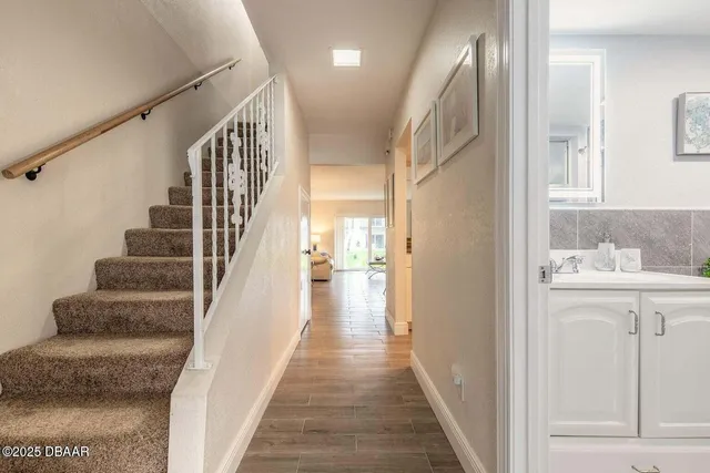 a view of a hallway with wooden floor and staircase