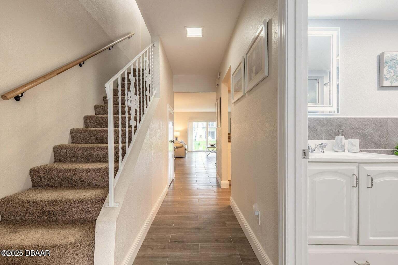 2750 Ocean Shore Boulevard, Unit 19 Ormond Beach, FL 32176 - Photo 11 of 23 a view of a hallway with wooden floor and staircase