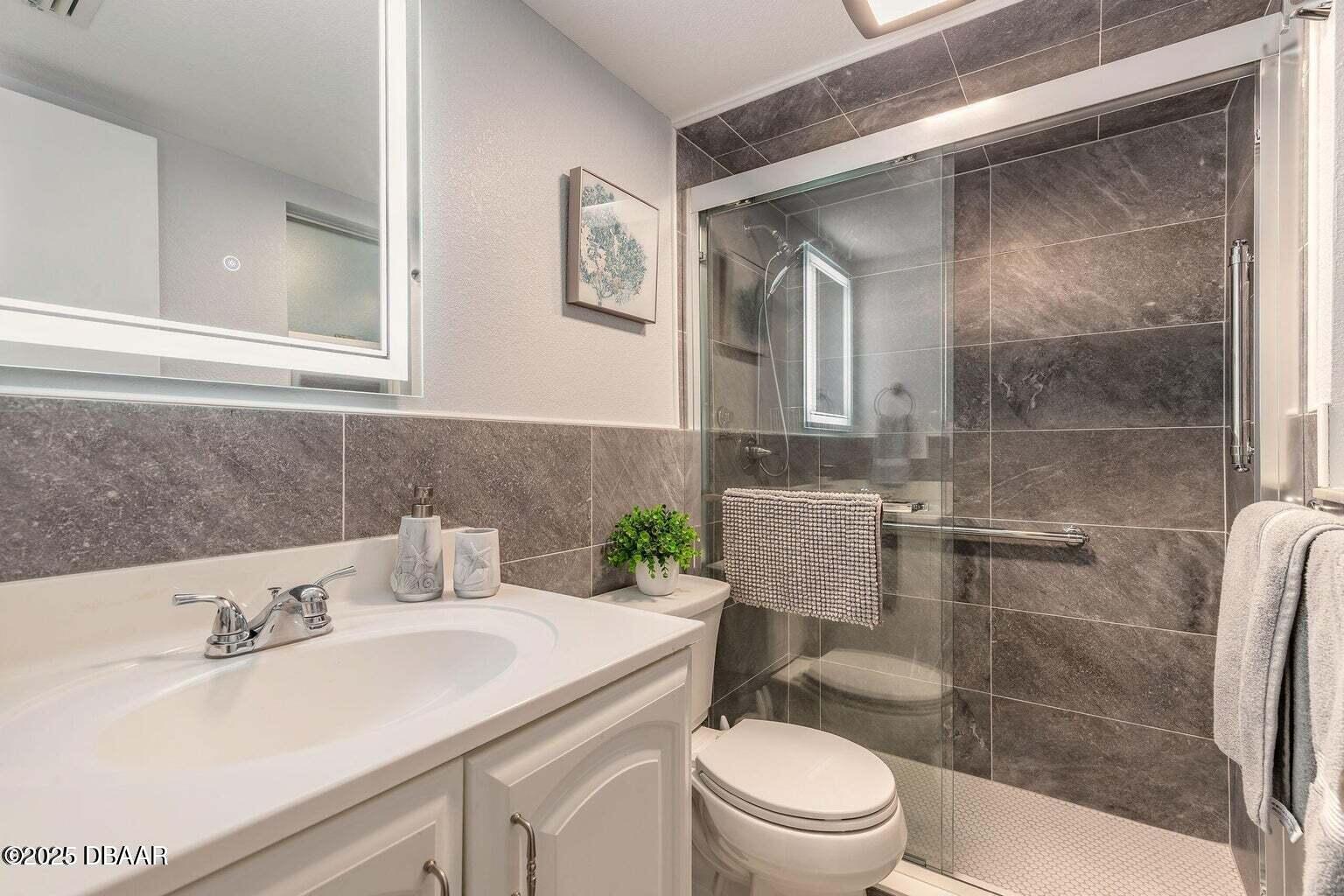 2750 Ocean Shore Boulevard, Unit 19 Ormond Beach, FL 32176 - Photo 10 of 23 a bathroom with a sink a toilet and shower