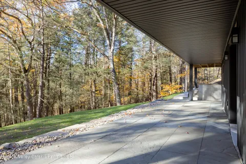 a view of a patio with a table and chairs next to yard with wooden fence