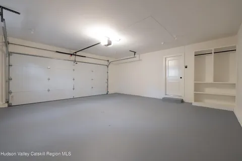 a front view of a house with a yard garage and a large tree