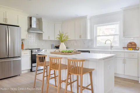 a kitchen with stainless steel appliances granite countertop a white cabinets and a refrigerator