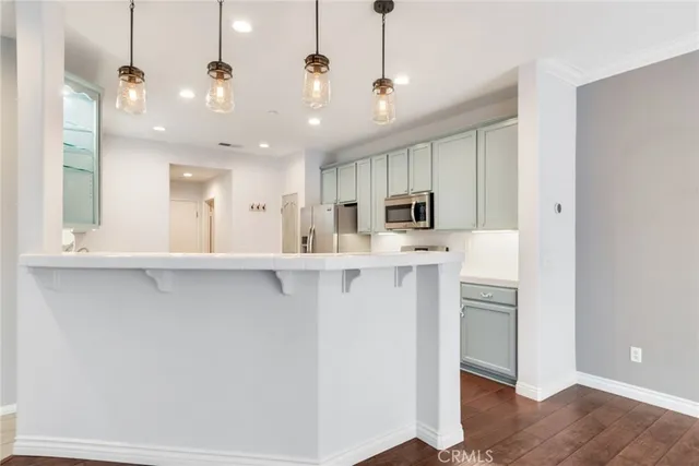 a view of a kitchen with stainless steel appliances refrigerator stove microwave and cabinets