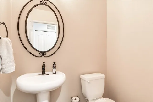 a bathroom with a toilet a sink and a mirror