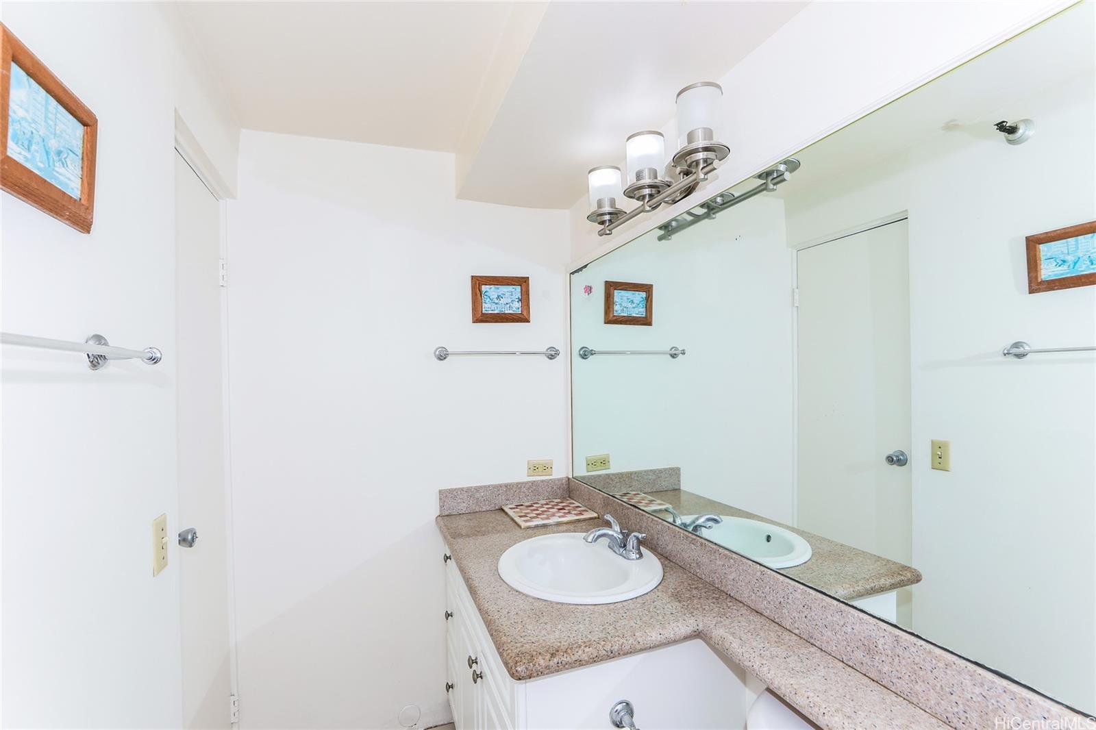 1700 Ala Moana Boulevard, Unit 603 Honolulu, HI 96815 - Photo 10 of 10 a bathroom with a granite countertop sink a mirror and a shower