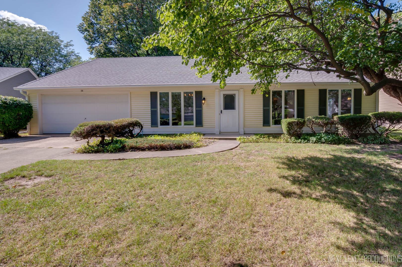 a front view of a house with a garden and plants
