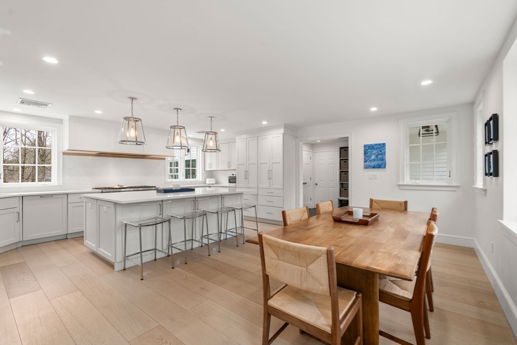 389 Grove Street Needham, MA 02492 - Photo 9 of 40 a kitchen with white cabinets and chairs