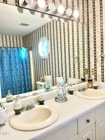 a bathroom with a double vanity sink and a mirror
