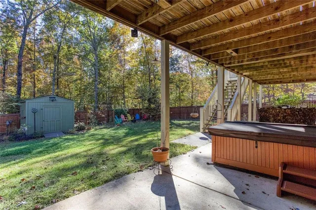 a view of a small house with a small yard and wooden fence