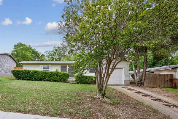 a view of a house with a tree in the yard