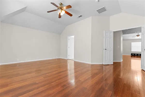 a view of empty room with wooden floor