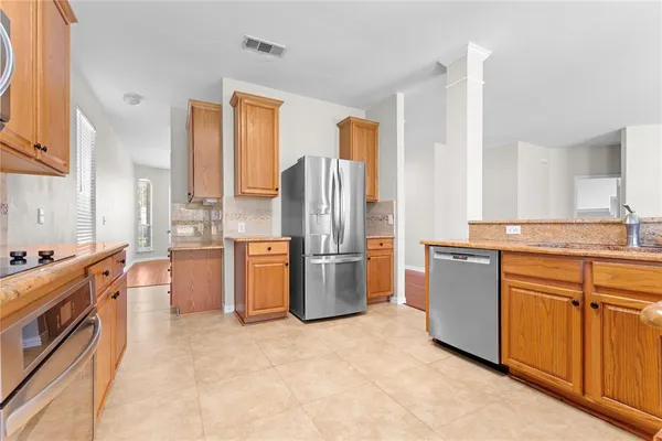 a kitchen with stainless steel appliances kitchen island granite countertop a refrigerator stove and sink