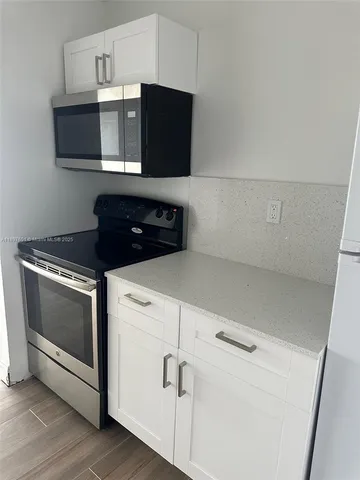 a kitchen with microwave cabinets and stove top oven