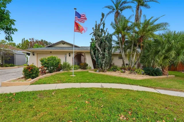 a front view of a house with a yard and palm trees