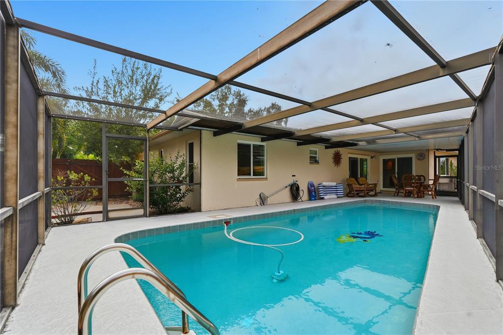 2370 Robyn Court Dunedin, FL 34698 - Photo 24 of 29 a view of a patio with a table and chairs under an umbrella
