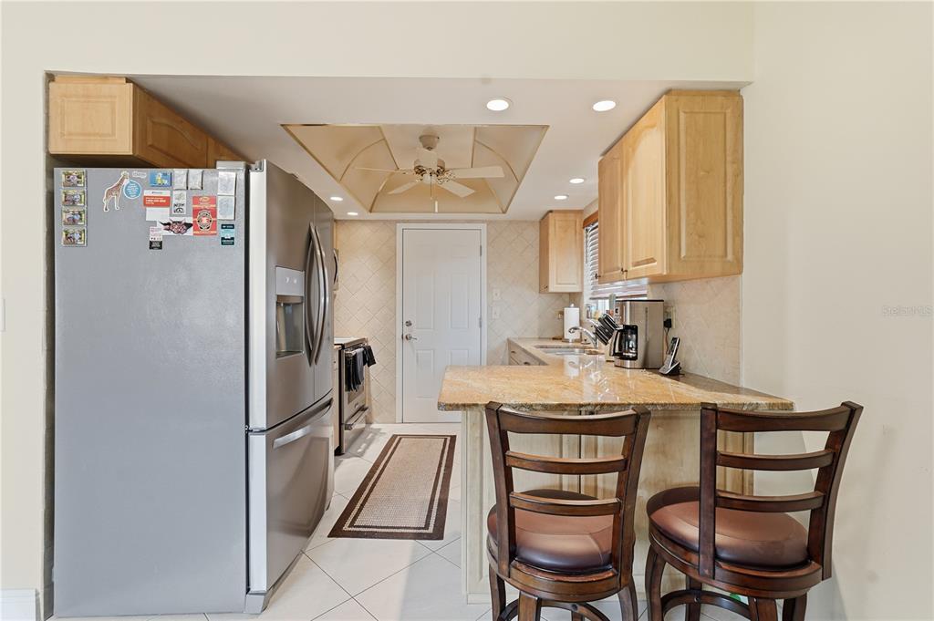 2370 Robyn Court Dunedin, FL 34698 - Photo 8 of 29 a kitchen with kitchen island a appliances dining table and chairs
