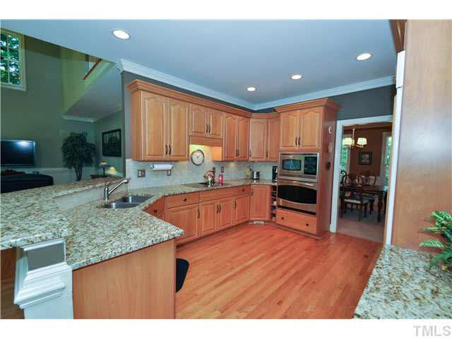 4209 White Chapel Way Raleigh, NC 27615 - Photo 9 of 25 The spectacular kitchen offers a place to gather with friends and family to enjoy the art of cooking. Granite counter tops, smooth ceilings, cherry cabinetry, stainless steel appliances, wood paneled refrigerator to blend, Kitchen
