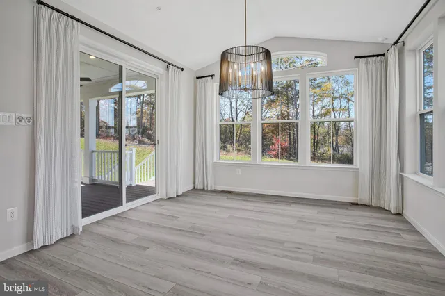 a large white kitchen with kitchen island a large window and a sink