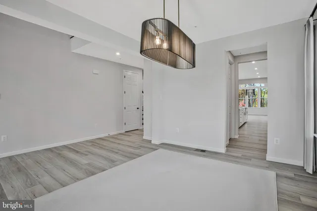 an empty room with window and hardwood floor