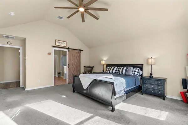 a spacious bedroom with a bed and a chandelier