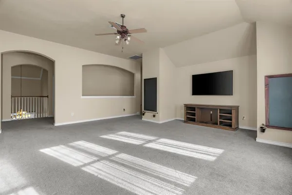 a living room with a flat screen tv and refrigerator