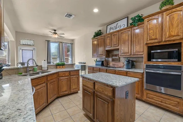 a kitchen with stainless steel appliances granite countertop a stove a sink and a microwave