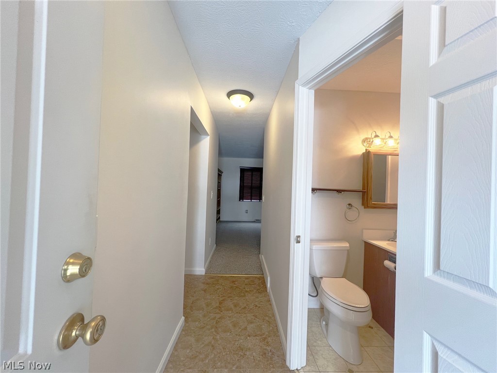5203 Ridgeland Street Lorain, OH 44055 - Photo 5 of 39 Bathroom featuring vanity, toilet, a textured ceiling, and tile floors