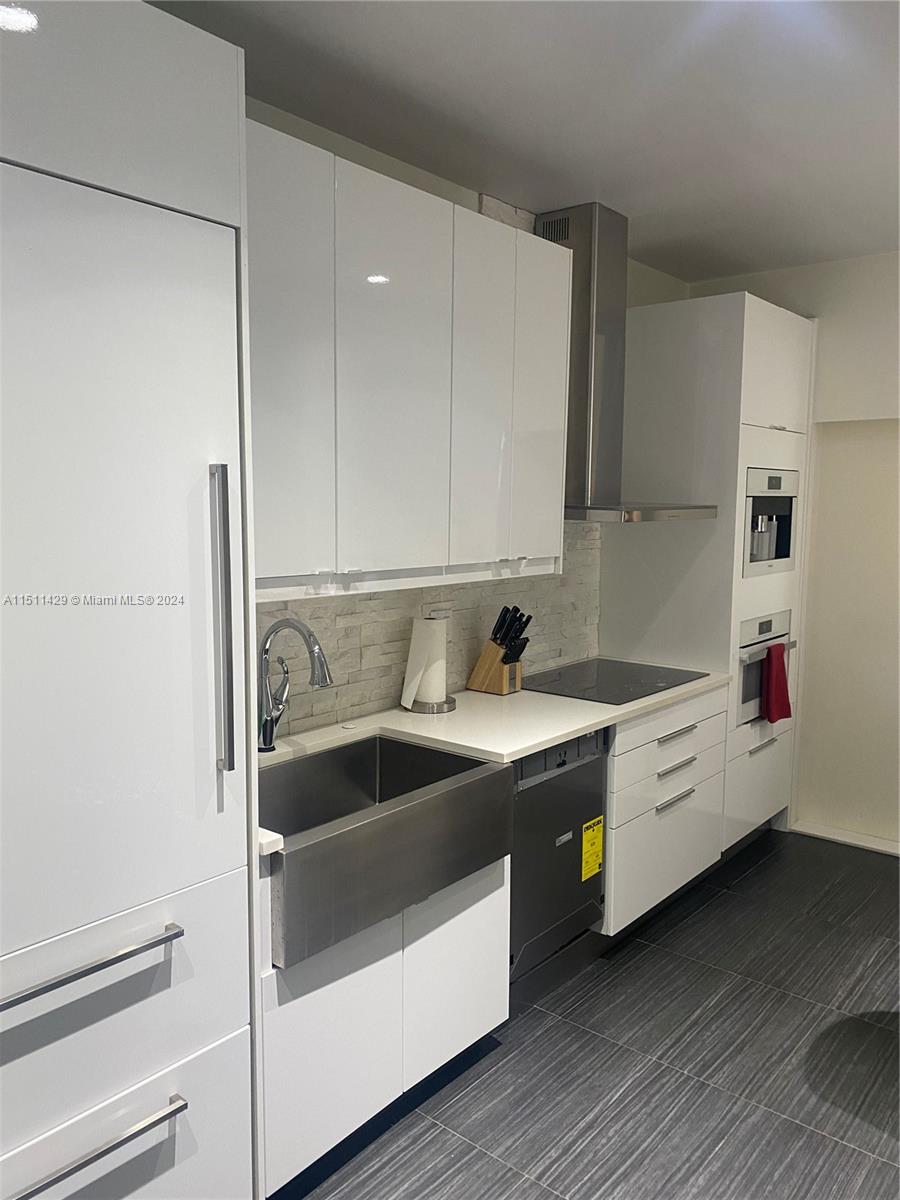 a kitchen with a white wooden floor and white appliances