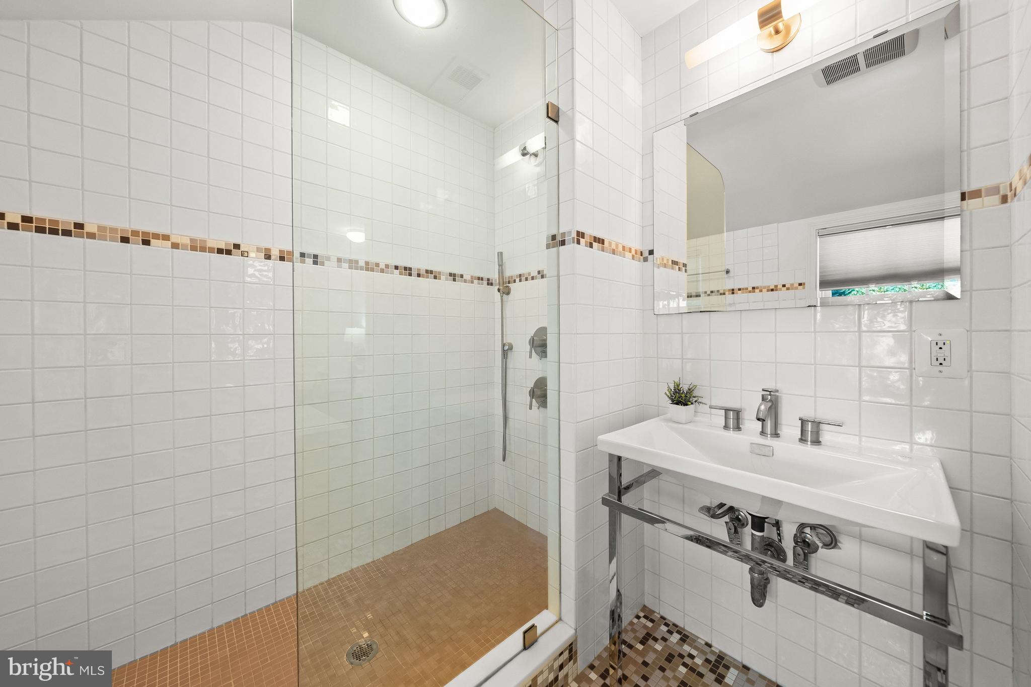 8800 Maywood Avenue Silver Spring, MD 20910 - Photo 19 of 41 a bathroom with a sink a mirror and a shower